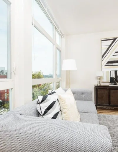 A living room with large windows and a couch.