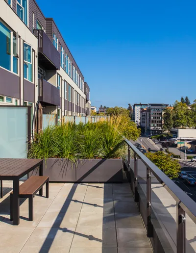 A balcony with a table and chairs overlooking a city.
